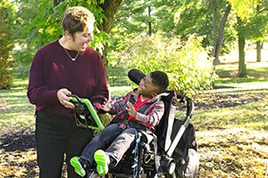 Image of a woman showing a child how to use a speech device